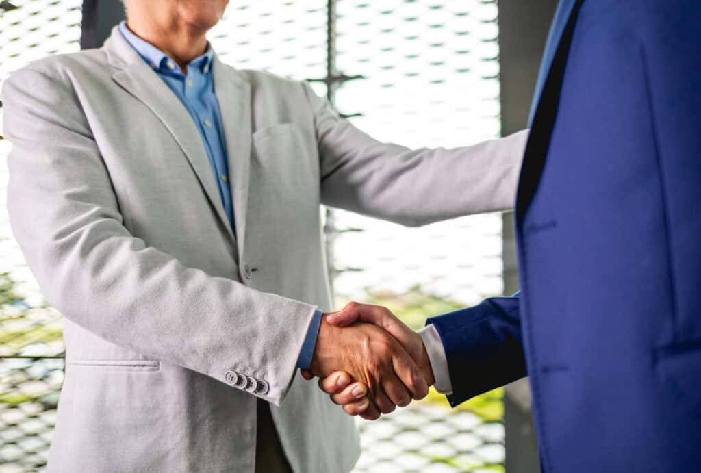 Business people shaking hands in the modern office finishing successful meeting
