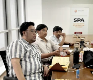 Peserta Fresh Graduate Development Program sedang berdiskusi dengan mentor selama sesi pelatihan SAP di Integra Solusi Mandiri.